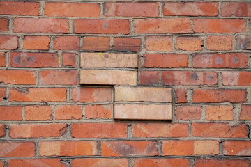 Fototapeta premium The texture of a fragment of a brick wall with a four-sided rectangular projection