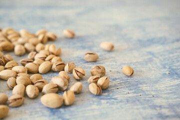 Close-up of Salted and dried Pistachios on the Blurred painted stone table as background. Concept of healthy nutrition. Selective focus. Copy space.