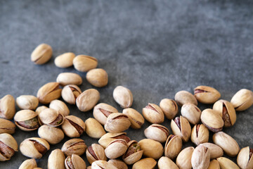 Top view of Salted and dried Pistachios on the Blurred painted stone table as background. Concept of healthy nutrition. Selective focus. Copy space.