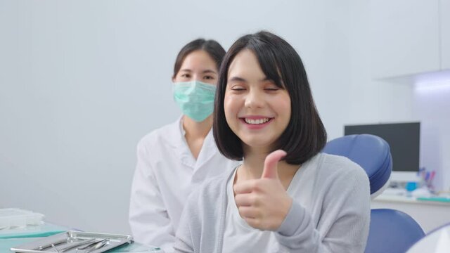Portrait of Asian female dentist and patient sitting in dental clinic.