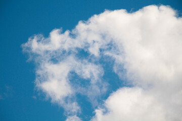 Air white clouds float across the blue summer sky