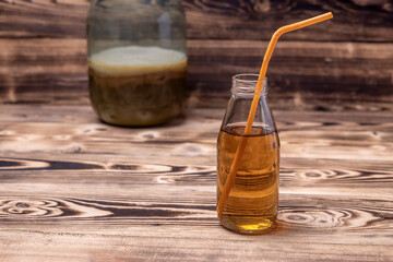 Kombucha cocktail in a bottle on a wooden background