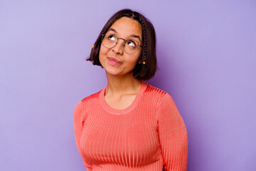 Young mixed race woman isolated on purple background dreaming of achieving goals and purposes