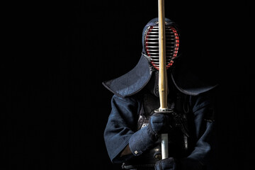 Japanese kendo fighter with with shinai on a black background