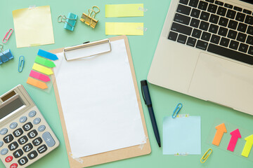 Work space with calculator, post-it, keyboard and Paper clip for financial report. Desktop modern business person. Accounting concept. green background.