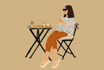 Woman in stripped sweater sitting at a table and having lunch. Eating croissant with coffee. French style. Spend time outdoors in the sun.