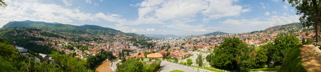 Naklejka na ściany i meble Panoramic view of Sarajevo the capital of Bosnia and Herzegovina. Houses, mountains, hills and roofs of the city seen from above