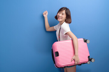 Portrait of young female traveler isolated over purple background studio.