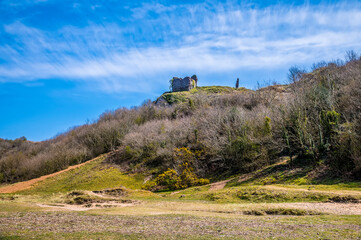 A view looking back towards the ruins of Pennard Castle on the way out to Three Cliffs Bay, Gower Peninsula, Swansea, South Wales on a sunny day