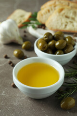 Concept of tasty eating with olive oil on gray textured table