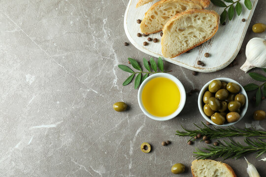 Concept of tasty eating with olive oil on gray textured table
