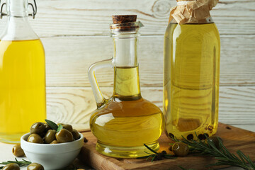 Bottles of olive oil against white wooden background