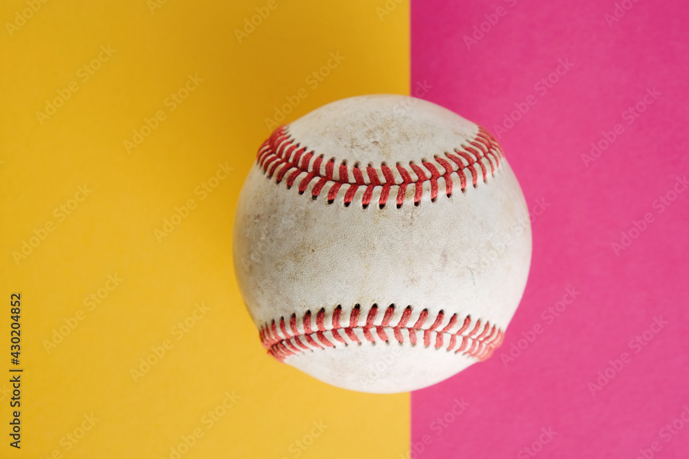 Wall mural used baseball on vibrant pink and yellow paper background with copy space for bright sports concept. - Wall murals