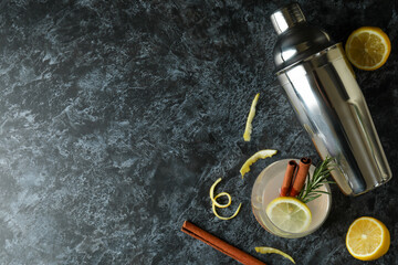 Glass of lemonade with cinnamon and rosemary on black smokey table