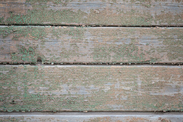 the wall is made of old boards with remnants of green paint. natural background