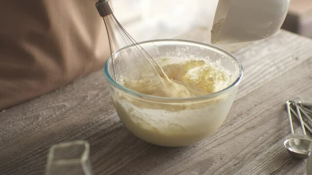 The hostess cook mixes flour with eggs with a whisk. preparation of batter. mixing the dough for baking. We are preparing breakfast in the home kitchen.