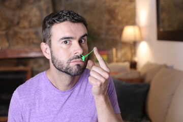 Comedic young man picking nose