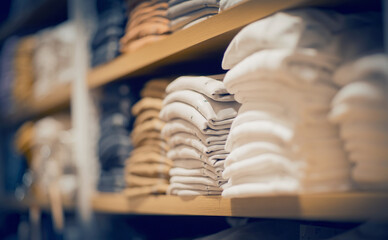 Stacks of clothes. Shopping in store. Clothing on the shelves in shop for sale.