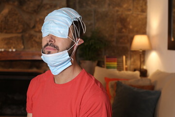 Man wearing several surgical masks the wrong way
