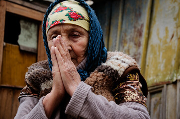 The old grandmother bowed her head in prayer. Grandma is praying. The old grandmother on the...