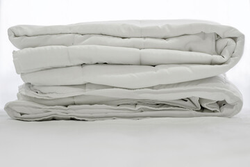 Closeup of beautiful white shiny crumpled  fabric sheets on the bed