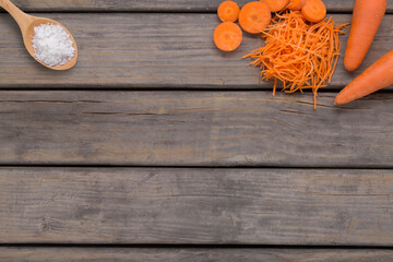 overhead view of rustic wood base with carrots and sea salt on the upper sides