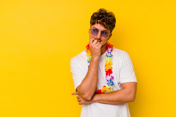 Young caucasian man wearing a Hawaiian party stuff isolated on yellow background relaxed thinking...