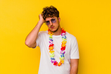 Young caucasian man wearing a Hawaiian party stuff isolated on yellow background being shocked, she...