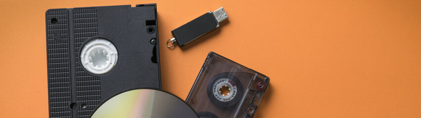 CD disk and video-audio cassette and flash drive as a concept of media storage evolution banner