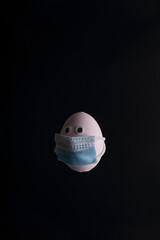 masked egg looks into the camera. Coronavirus medical concept