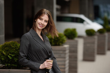 Fototapeta premium Portrait of a smiling businesswoman, outdoors.Beautiful girl with coffee.