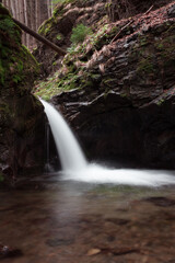 Fototapeta na wymiar Small waterfall in the mountains in long exposure
