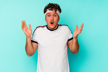 Fototapeta premium Young sport caucasian man isolated on blue background surprised and shocked.