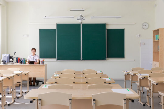 Young Pretty Teacher Woman In Class At School Sitting At Her Desk With Computer Before Exam