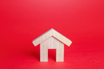 Obraz na płótnie Canvas Wooden house on a red background. Buying and selling. Housing, realtor services. Mortgage loan. Renovation and home improvement. Building maintenance. Rent of apartments and houses.