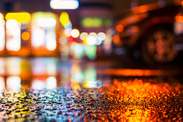Rainy night in the city. Parking mall with cars. Reflections of shop windows on wet asphalt....