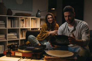 couple enjoying time at home, listening record on record player