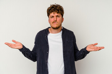 Young caucasian man isolated on white background doubting and shrugging shoulders in questioning...