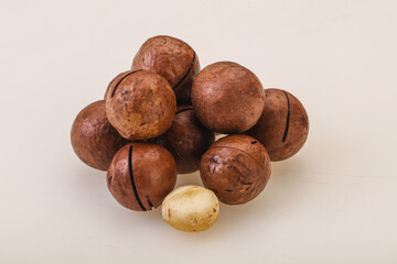 Brown macadamia nut heap over background