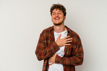 Young caucasian man isolated on white background laughs happily and has fun keeping hands on...
