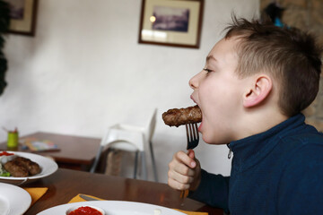 Child eating veal lula kebab