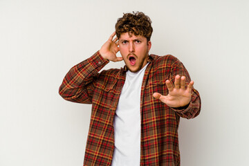 Young caucasian man isolated on white background being shocked due to an imminent danger