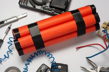 a bomb, a wire tool and an old mobile phone are being assembled on a white table as a timer before the explosion. the concept of terrorism and contract killing.
