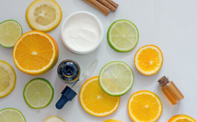 Natural citrus cosmetics with vitamin C, cosmetic bottles, citrus circles, lime, orange, lemon, top view, flat lay, copy space