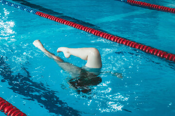 synchronized swimming athlete trains alone in the swimming pool. Training in the water upside down....