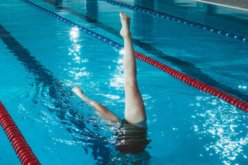 synchronized swimming athlete trains alone in the swimming pool. Training in the water upside down....