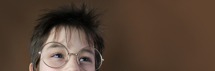boy, part of the face, funny eyes in round glasses close-up, looking straight, childhood concept,...