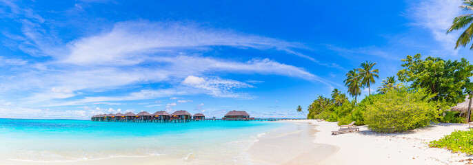 Amazing panorama at Maldives. Luxury resort villas seascape with palm trees, white sand and blue...