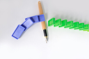 close-up fountain pen stops dominoes falling, colored domino cubes fall one after another, business...