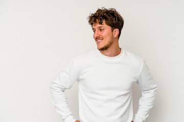 Fototapeta premium Young caucasian man isolated on white background laughs happily and has fun keeping hands on stomach.